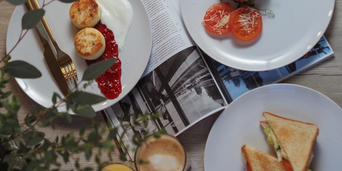 Overhead view of a stylish breakfast setup with toast, pastries, and beverages.