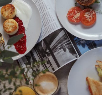 Overhead view of a stylish breakfast setup with toast, pastries, and beverages.