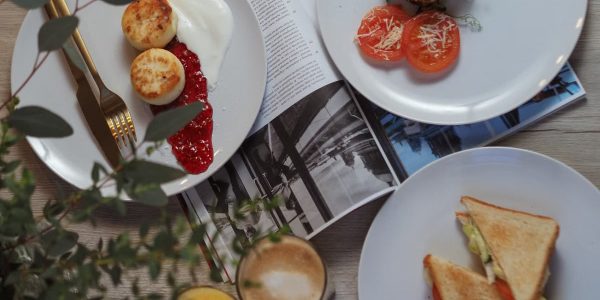 Overhead view of a stylish breakfast setup with toast, pastries, and beverages.